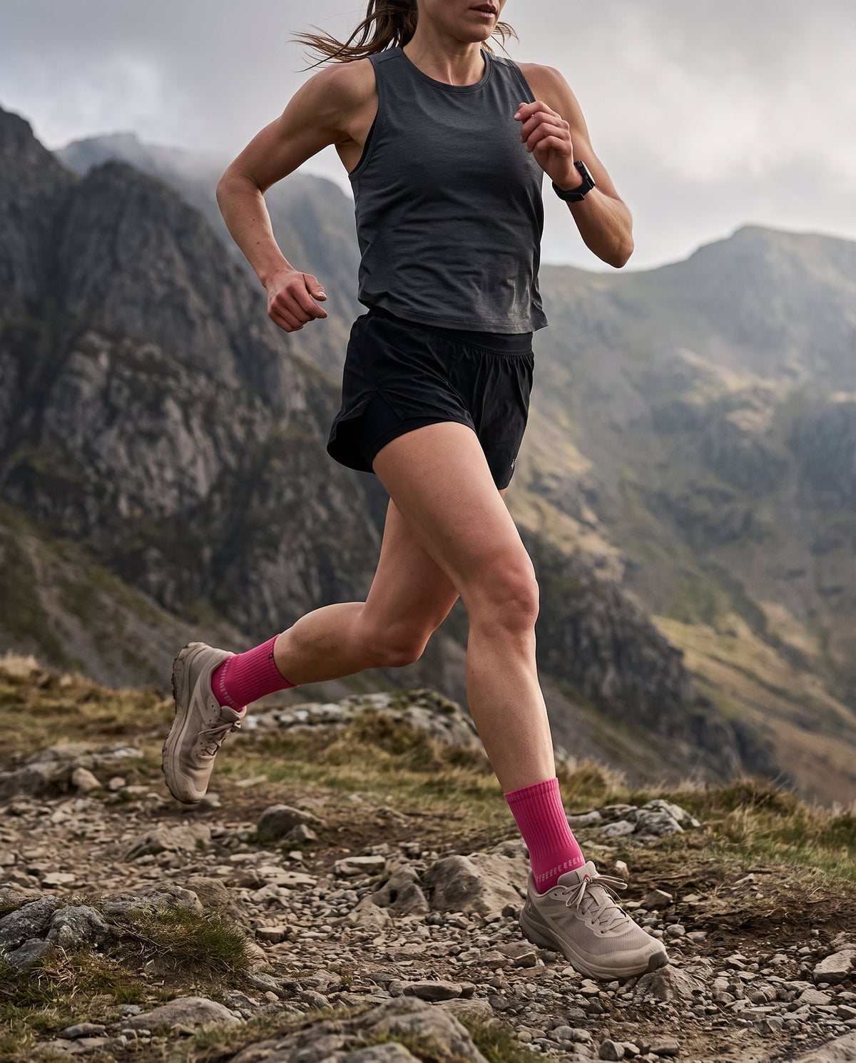 Trail runner in SEDZ Crimson Pink running socks on a rocky mountain path